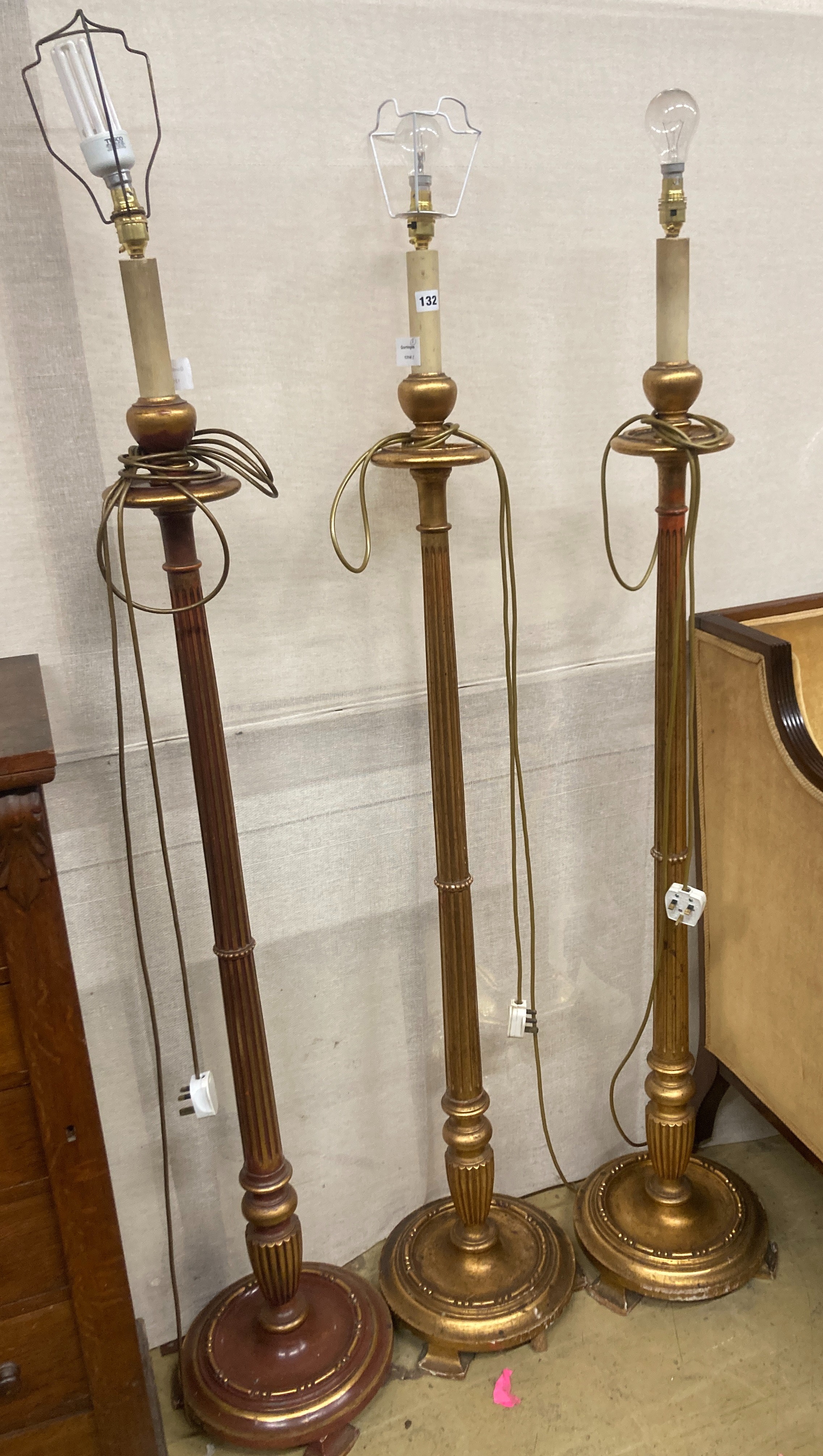 A set of three gilt carved wood lamp standards, height excluding fittings 135cm